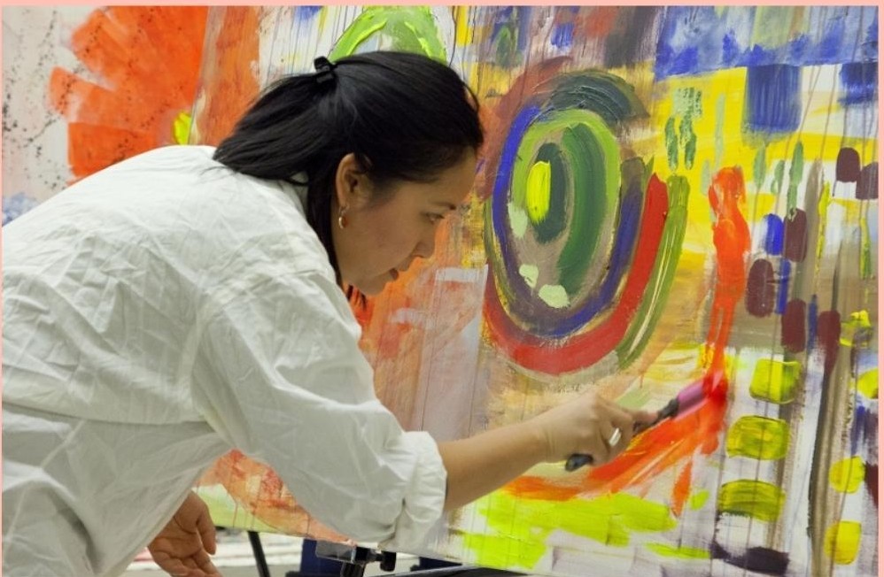 a photo of a woman artist painting a picture