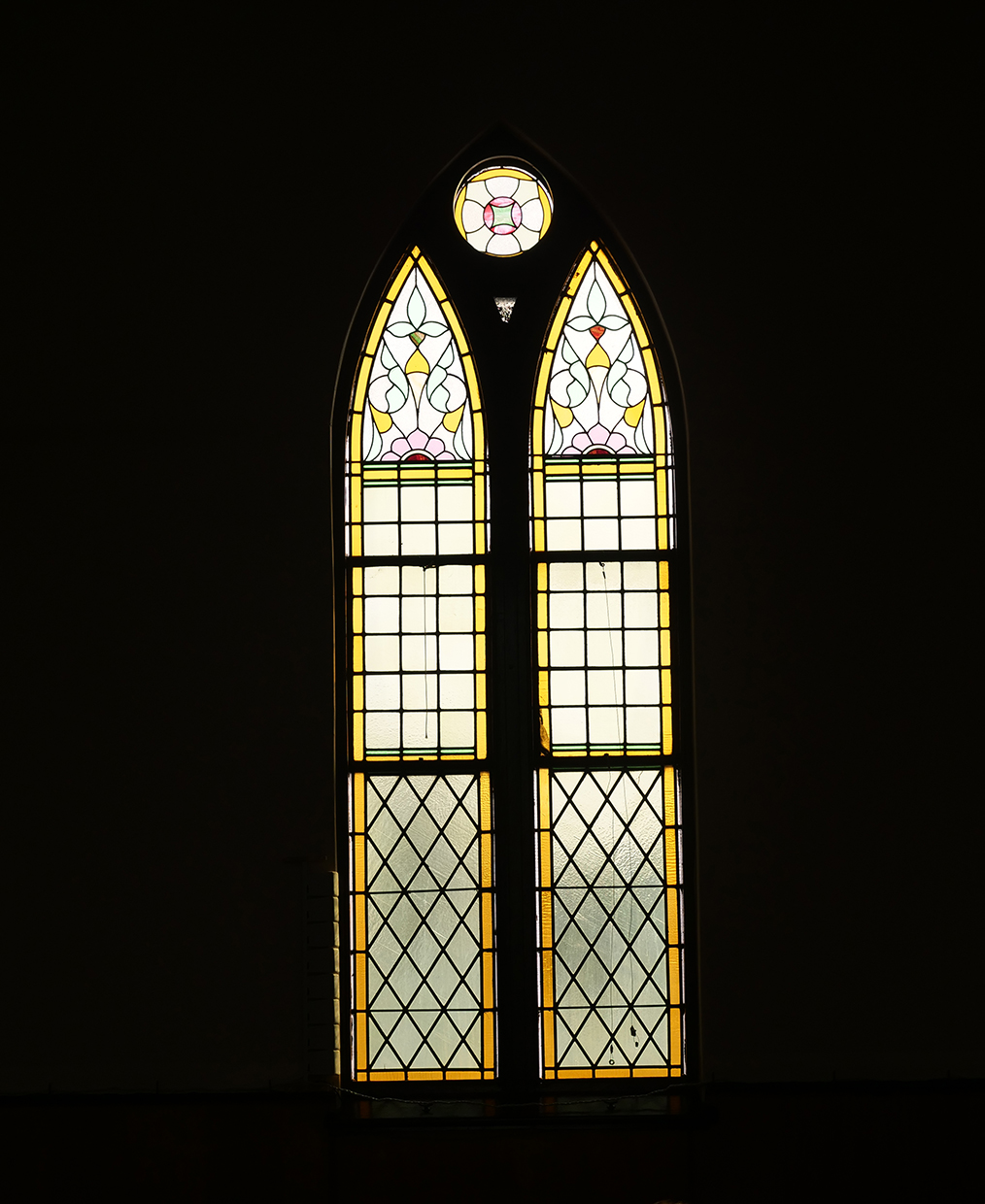 two tall stained glass windows with a point at the top of each