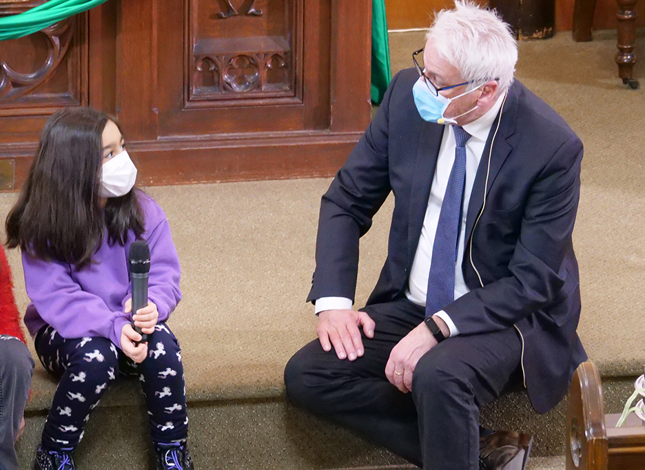 a young girl with Pastor Thomas on the alter