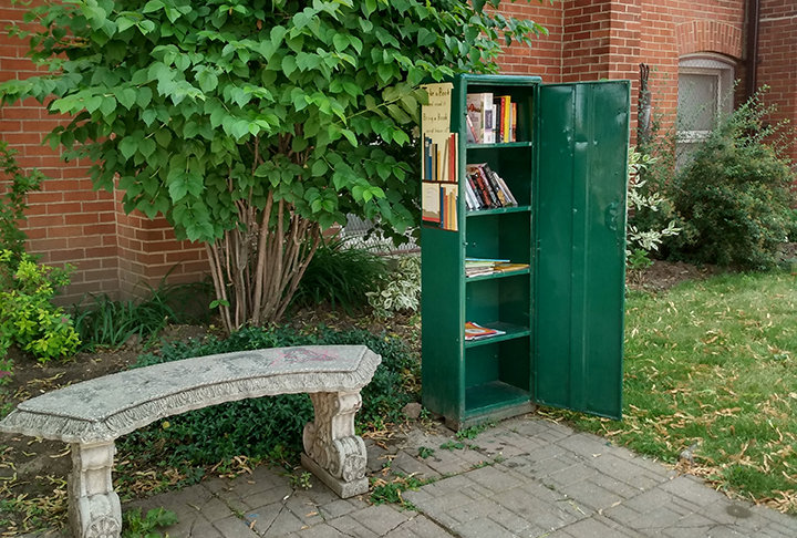 a metal locker that is the little library outside in front of Trinity Church