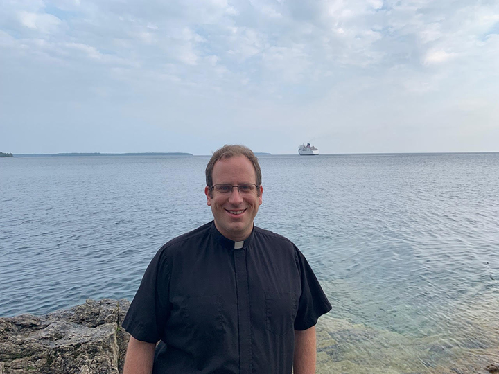 Pastor Jordan Smith standing in front of a body of water