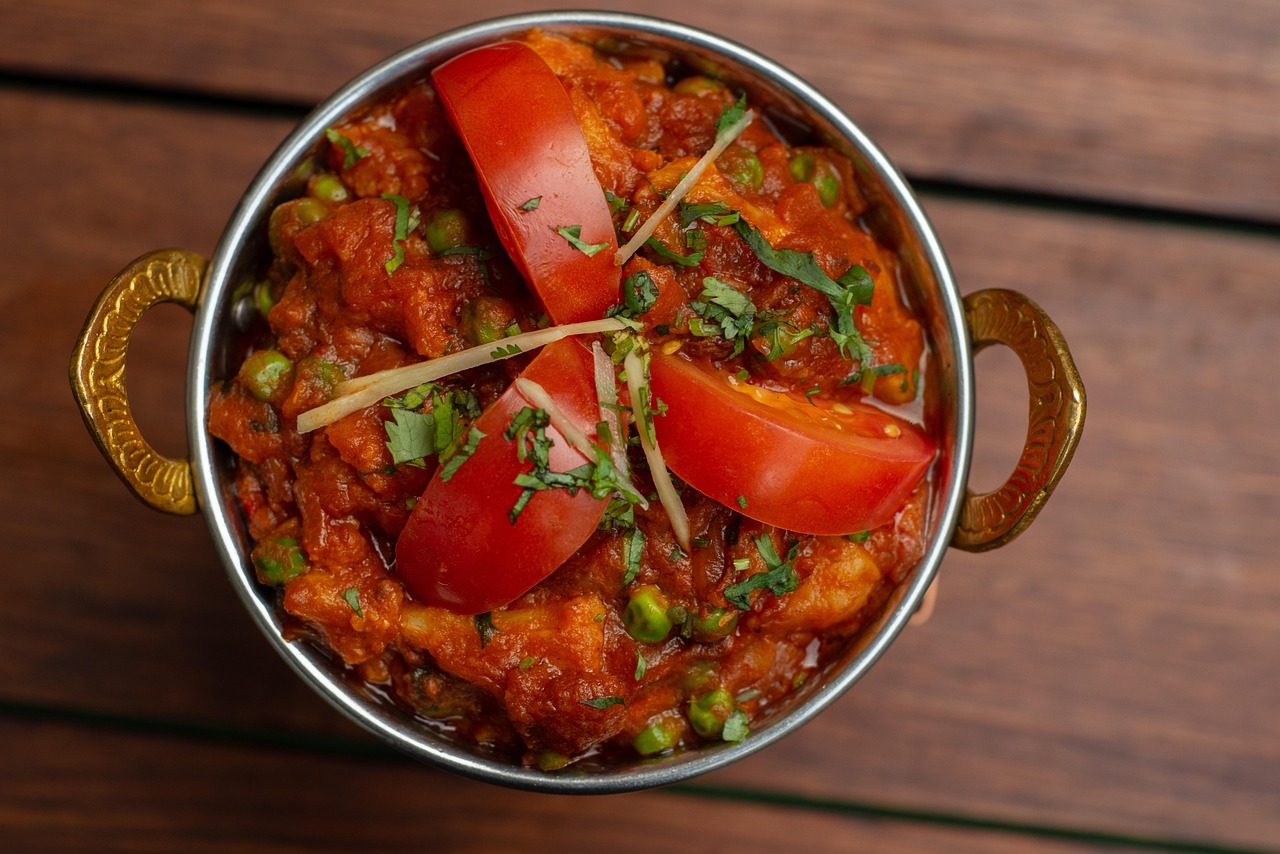a large pot of food with slices of tomatoes on the top