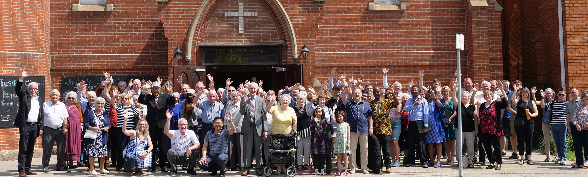 Trinity Lutheran Church congregation waving in front of the church building