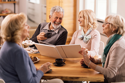 a group of seniors sitting around a table laughing and talking.