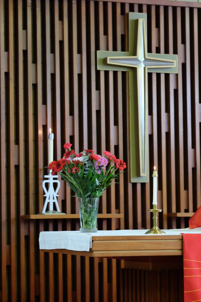 the alter at the front of Trinity church with a large cross and candles lit