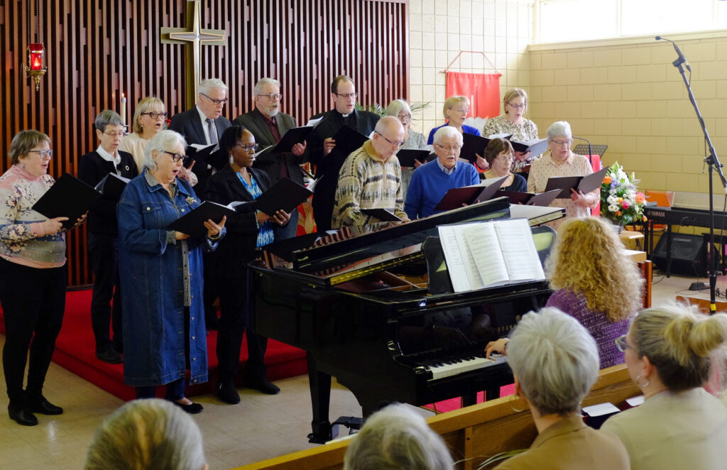 the Trinity church choir singing at the alter and the music director playing the piano